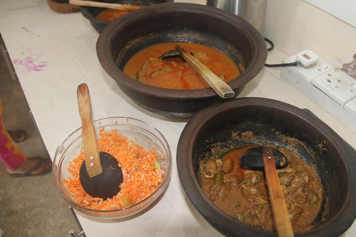 three pots of food on a stove with wooden spoons