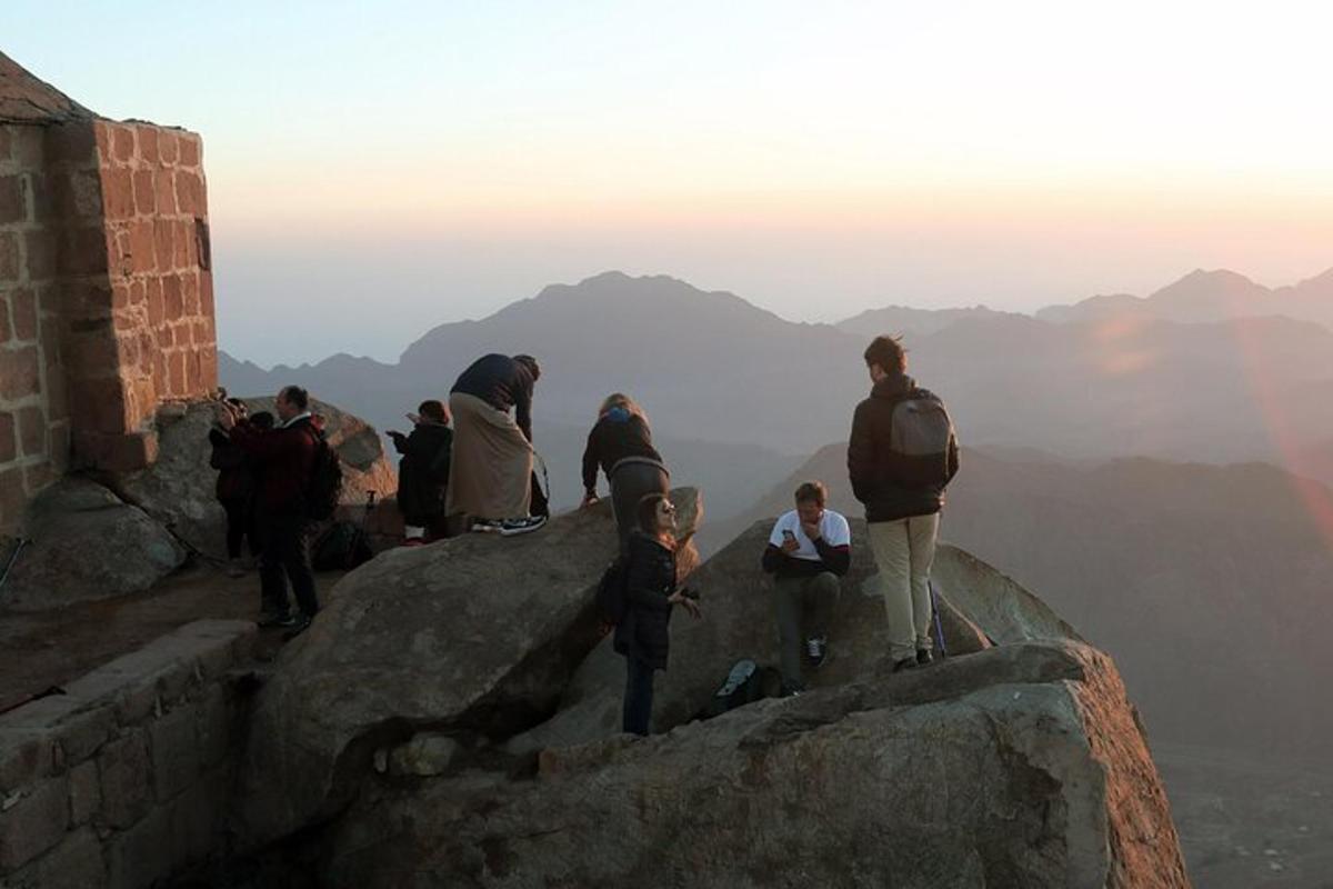 un grupo de personas de pie en la cima de una montaña