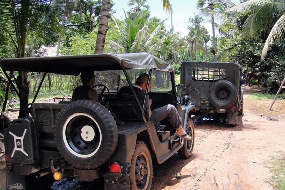 un bărbat care călărește într-un jeep cu un bărbat așezat
