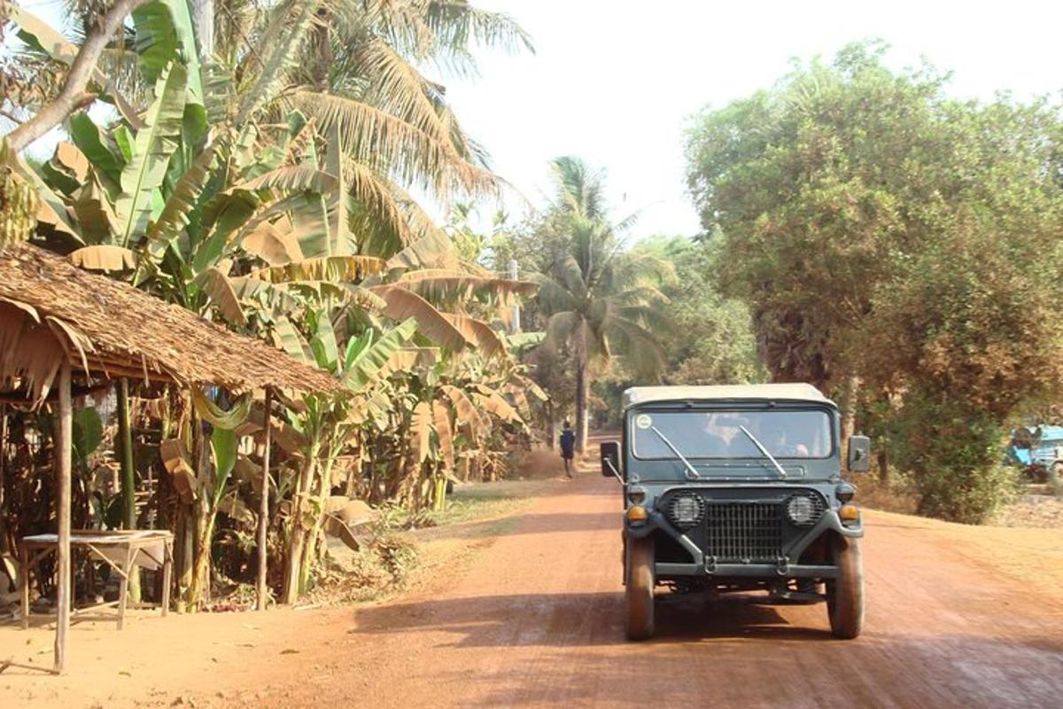 un jeep vechi mergând pe un drum de pământ