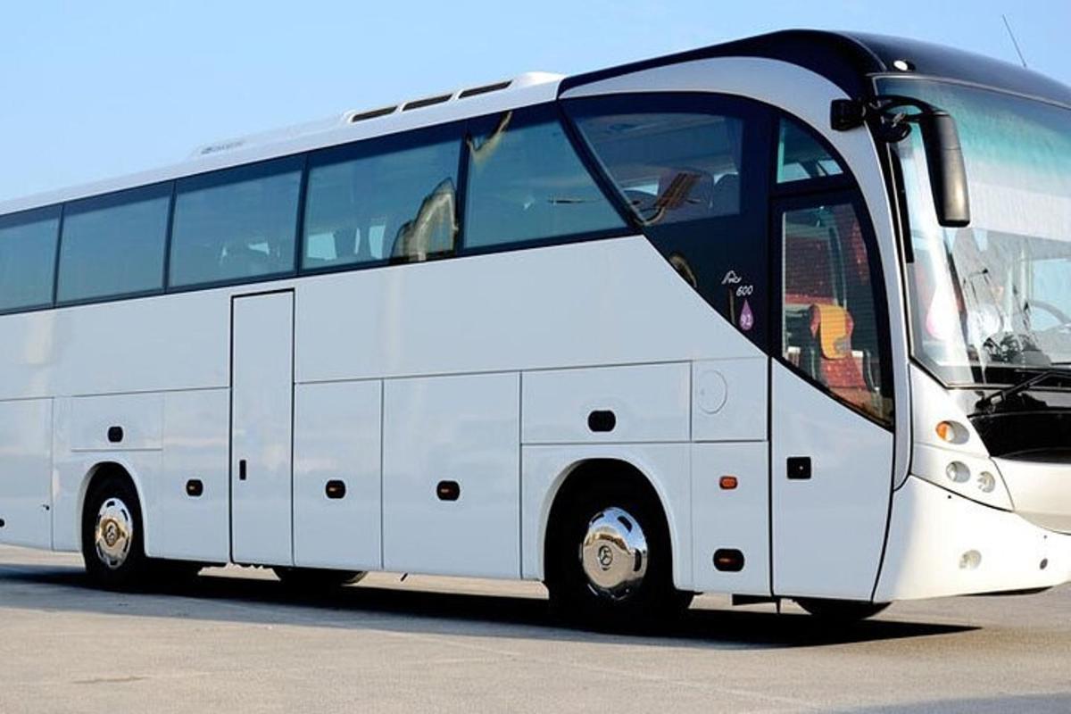 một chiếc xe buýt màu trắng đỗ trong bãi đậu xe