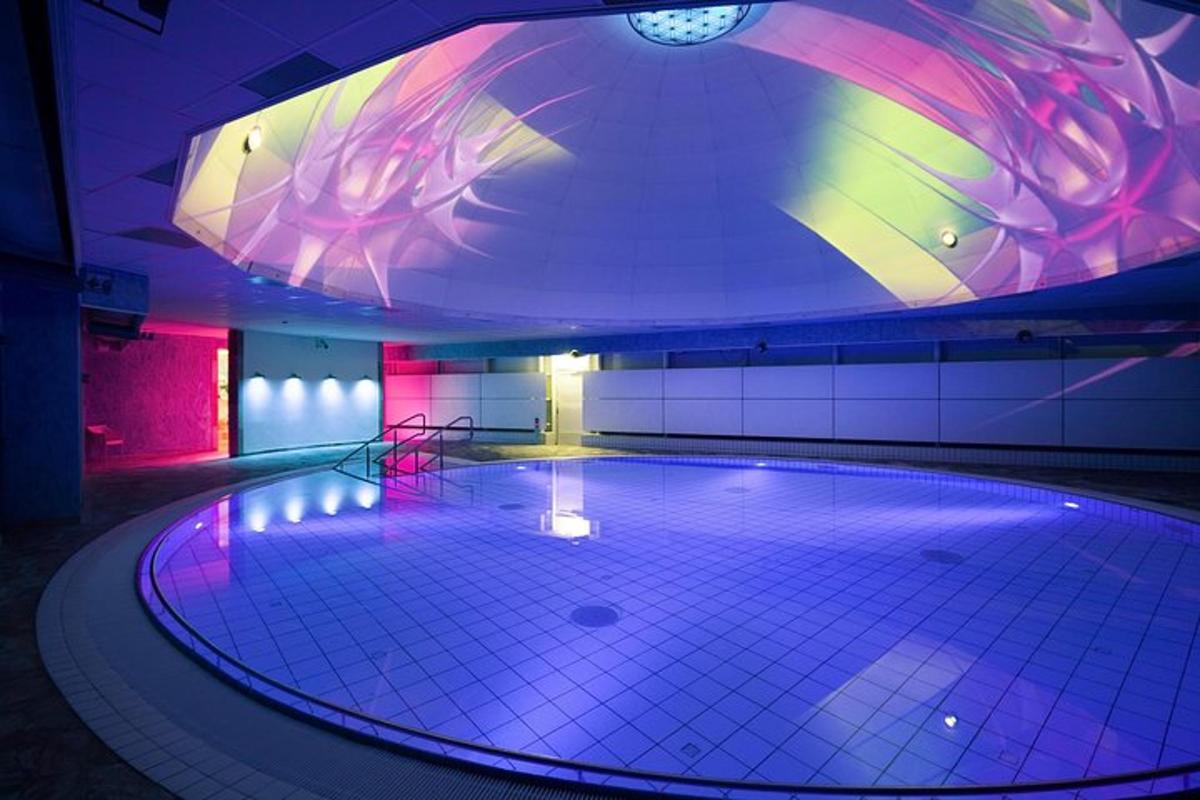 uma piscina em um prédio com teto iluminado