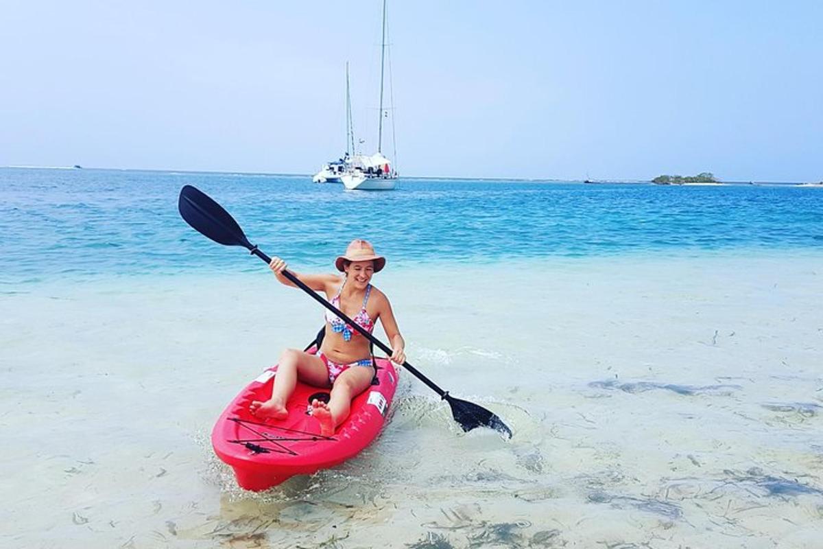 isang babae ang nakaupo sa isang kayak sa dalampasigan