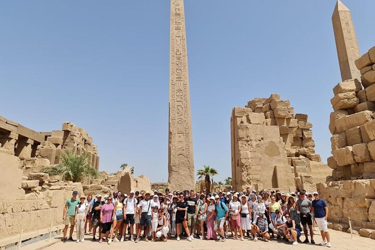 a group of people standing in front of a obelisk