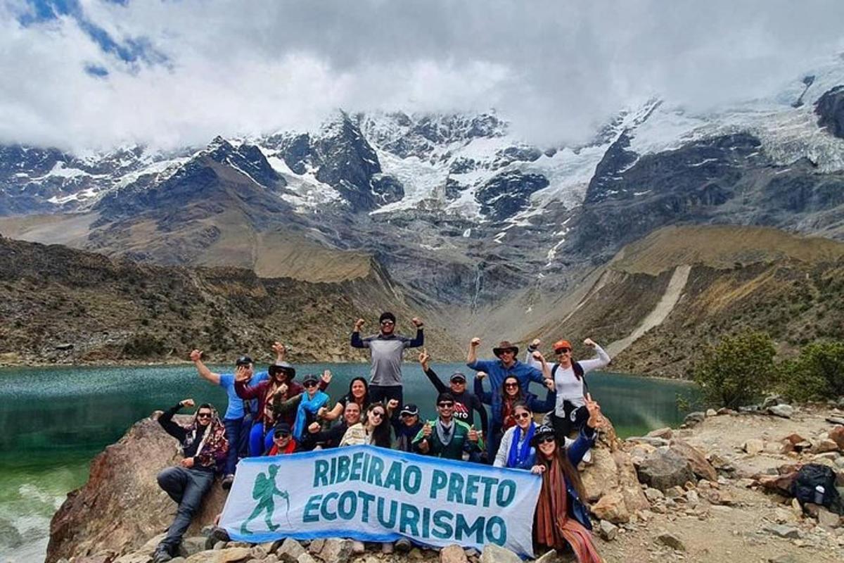 un grup de persones dretes a una muntanya amb un cartell