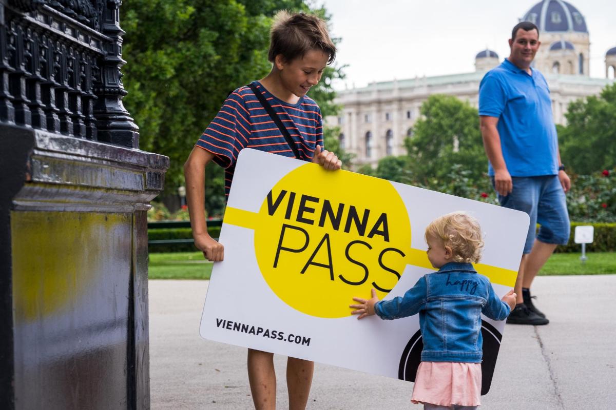 malé dítě držící ceduli s nápisem Vienna Pass