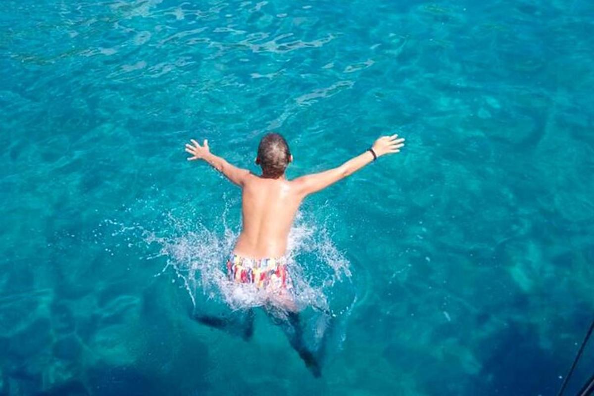 un uomo che cavalca un delfino nell'acqua