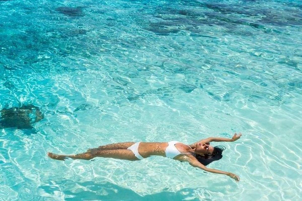 a woman laying in the clear blue water