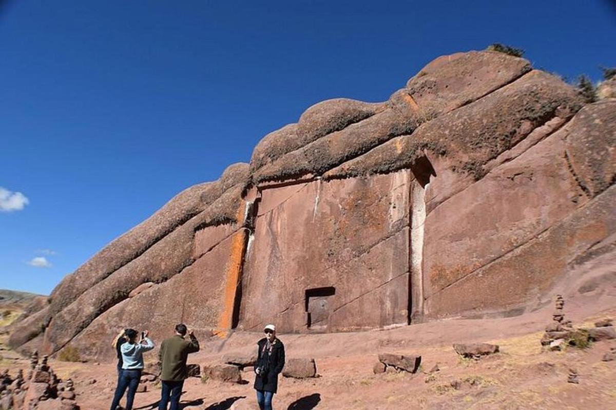 un gruppo di persone in piedi accanto a una grande roccia