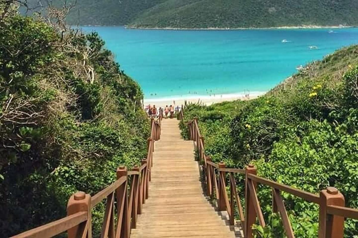 un sentiero di legno che conduce a una spiaggia con persone su di esso