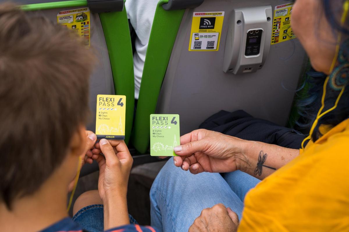 Dos personas sentadas en un tren sosteniendo carteles