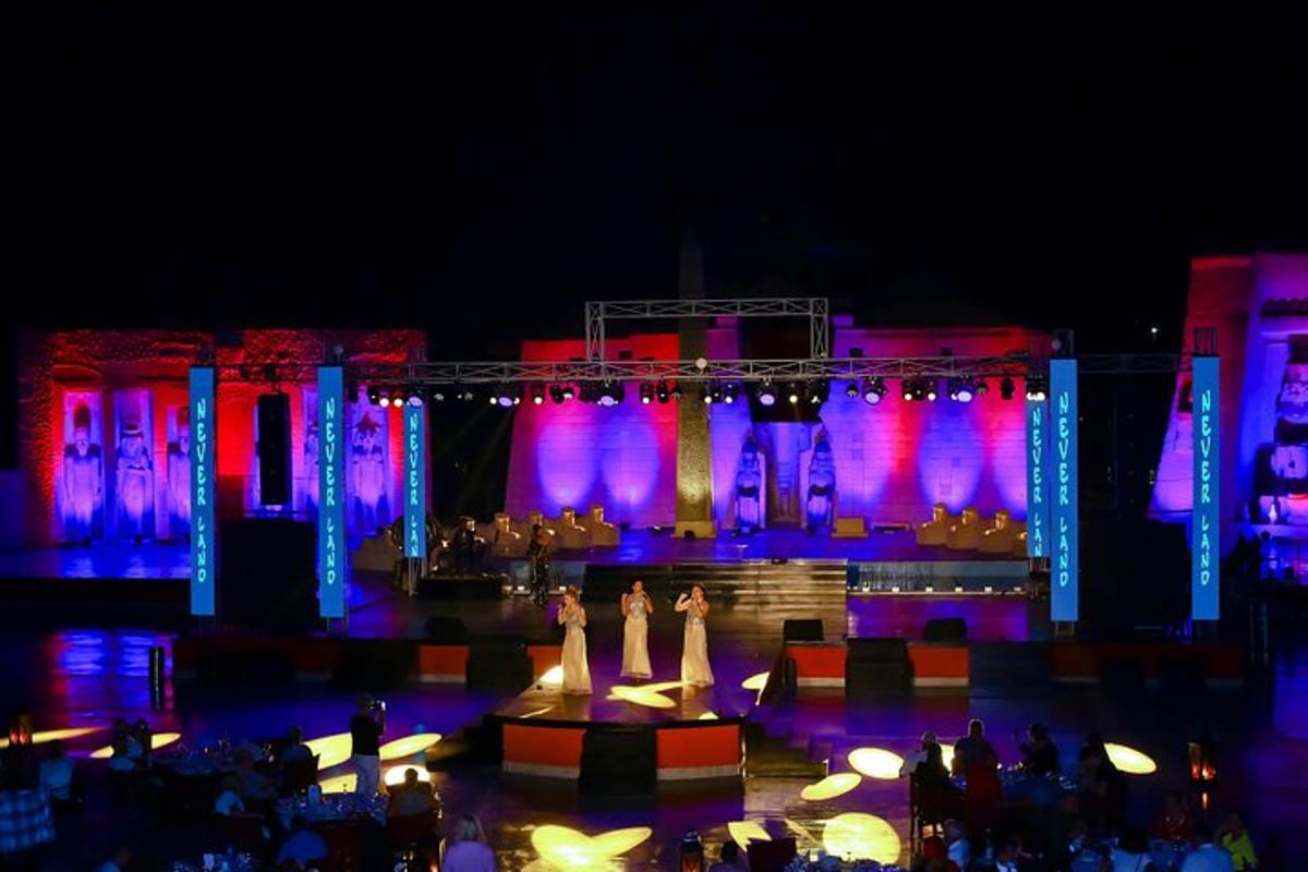 a group of people standing on a stage at night
