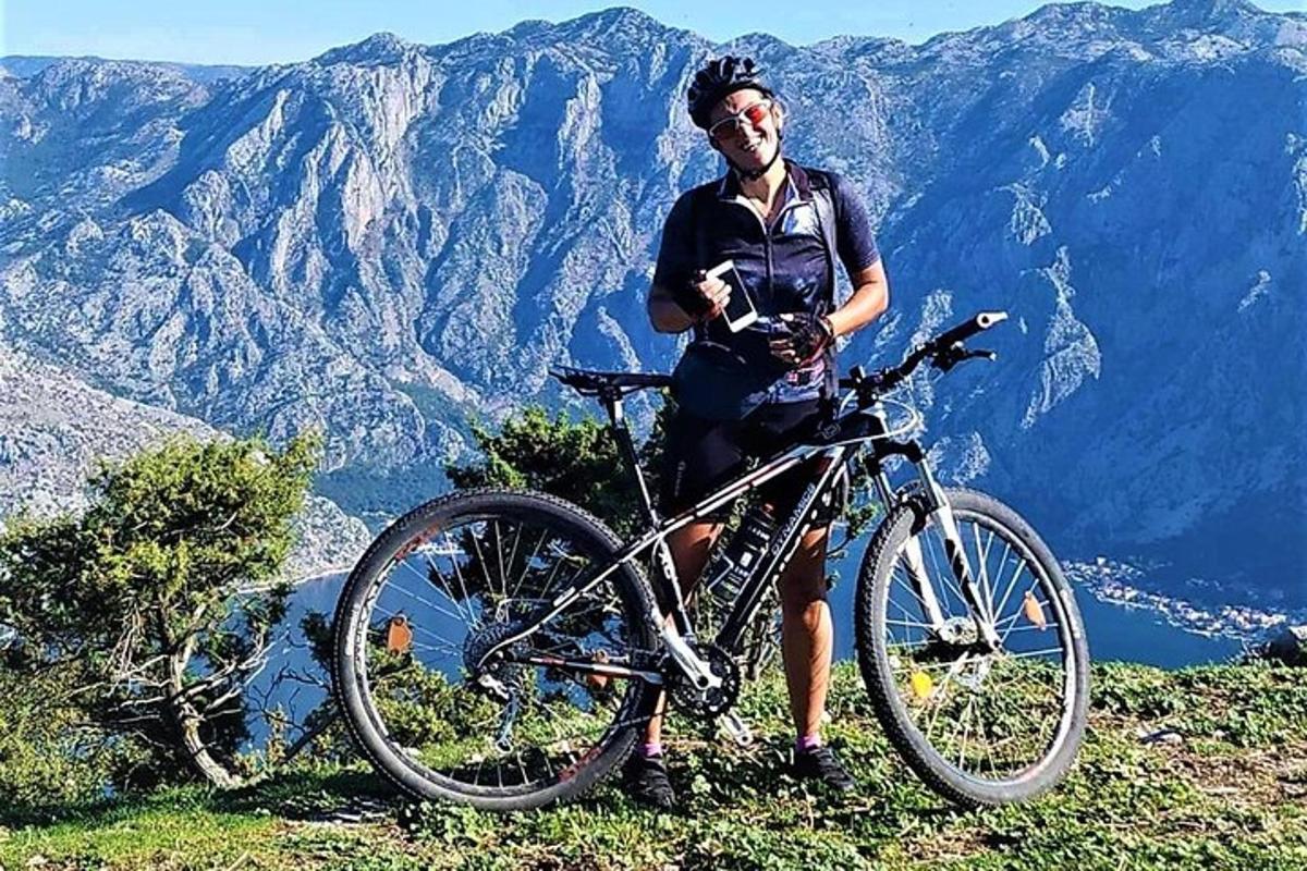 Un hombre parado junto a una bicicleta en una montaña