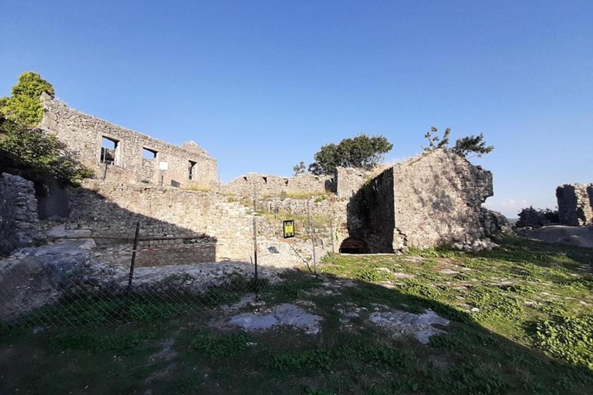 um antigo edifício de pedra em uma colina gramada