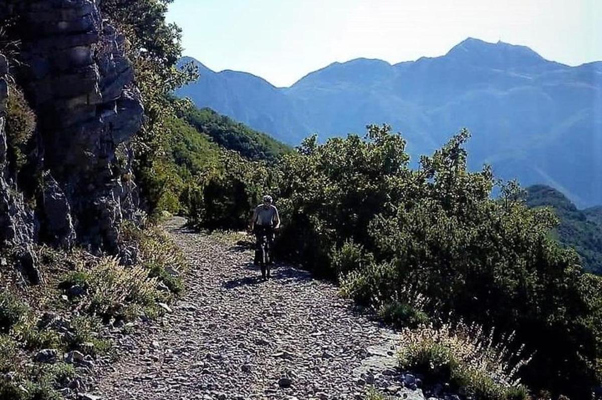osoba jedoucí na kole po horské stezce