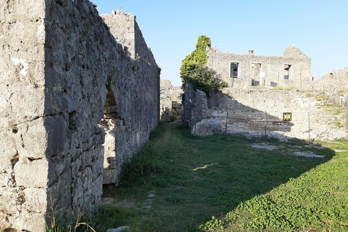 um antigo edifício de pedra com um campo de grama ao lado