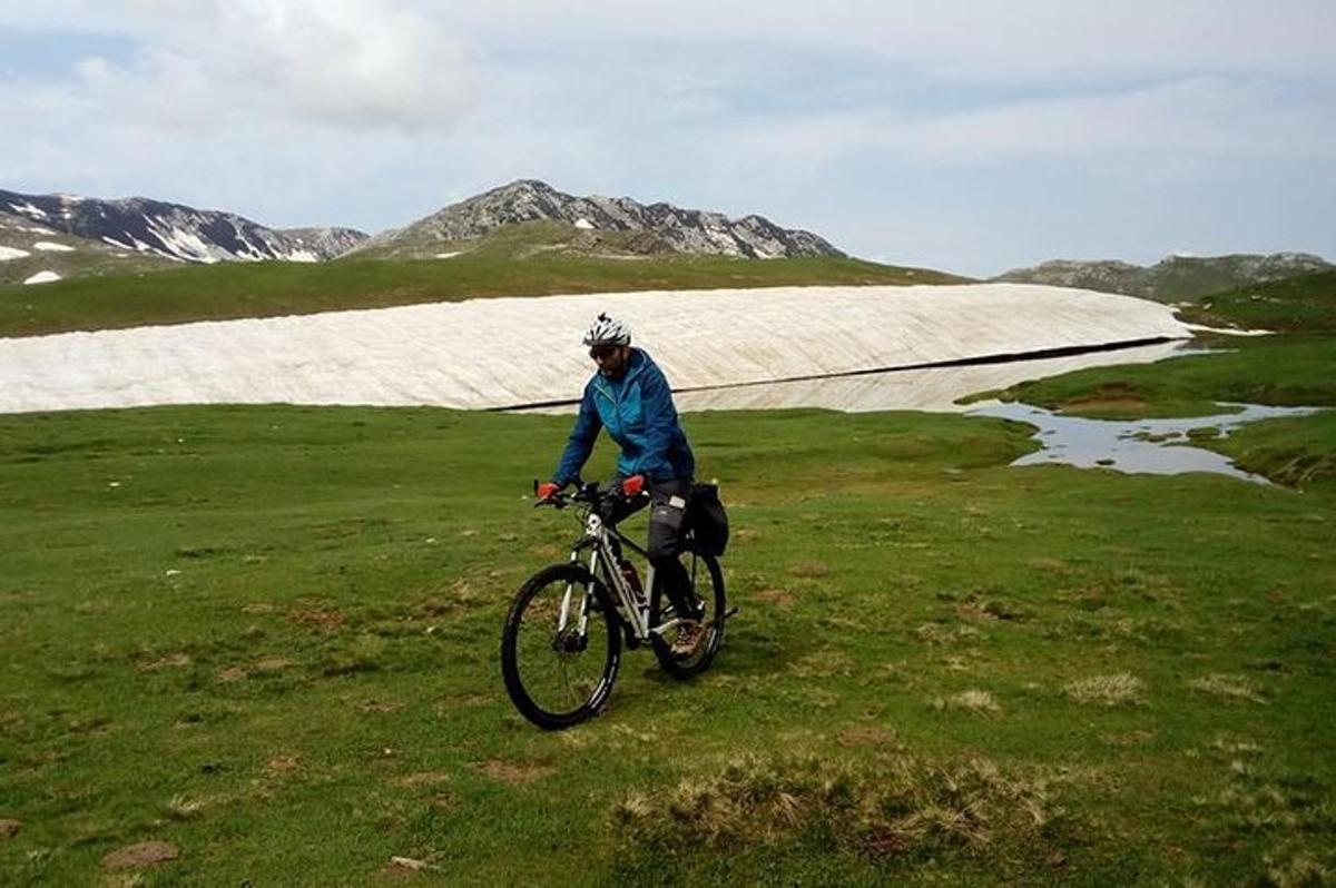 cilvēks brauc ar velosipēdu pa lauku