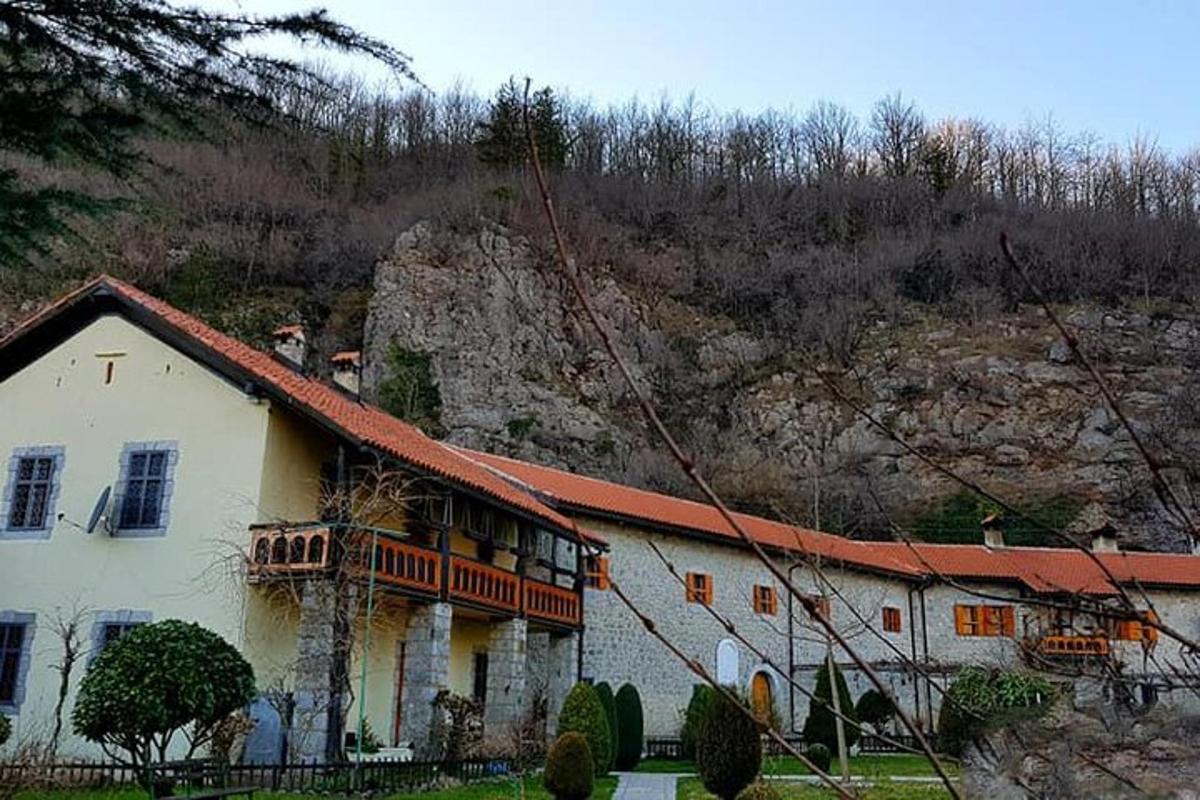 Una gran casa blanca con una montaña al fondo.