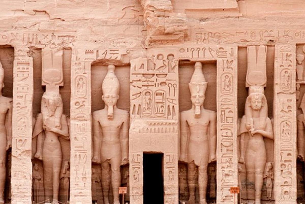 Un muro de piedra con estatuas de hombres.