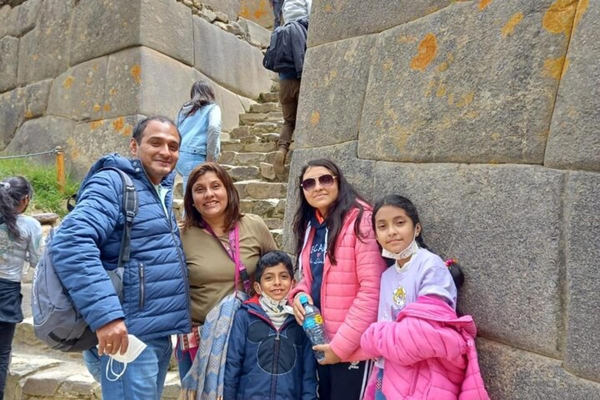 un grup de persones dretes al costat d'un mur de pedra