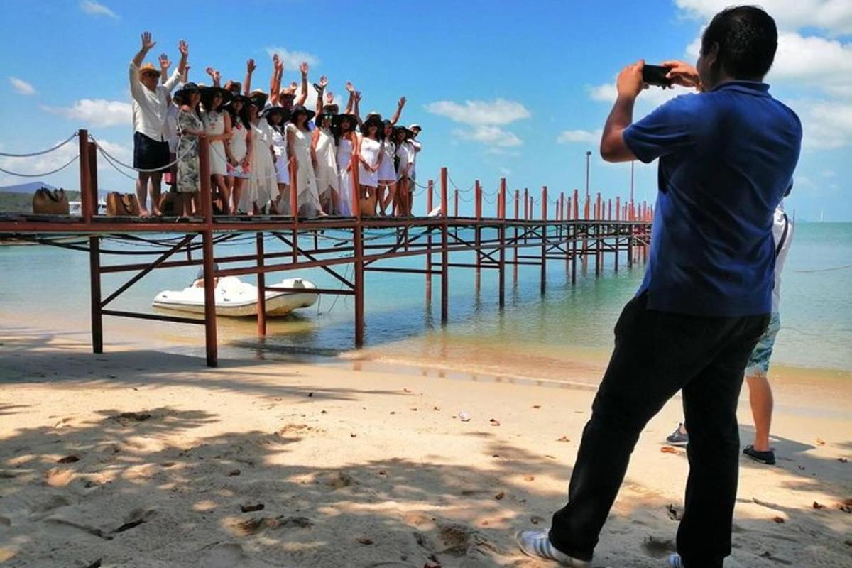 un uomo che scatta una foto a un gruppo di persone su un molo