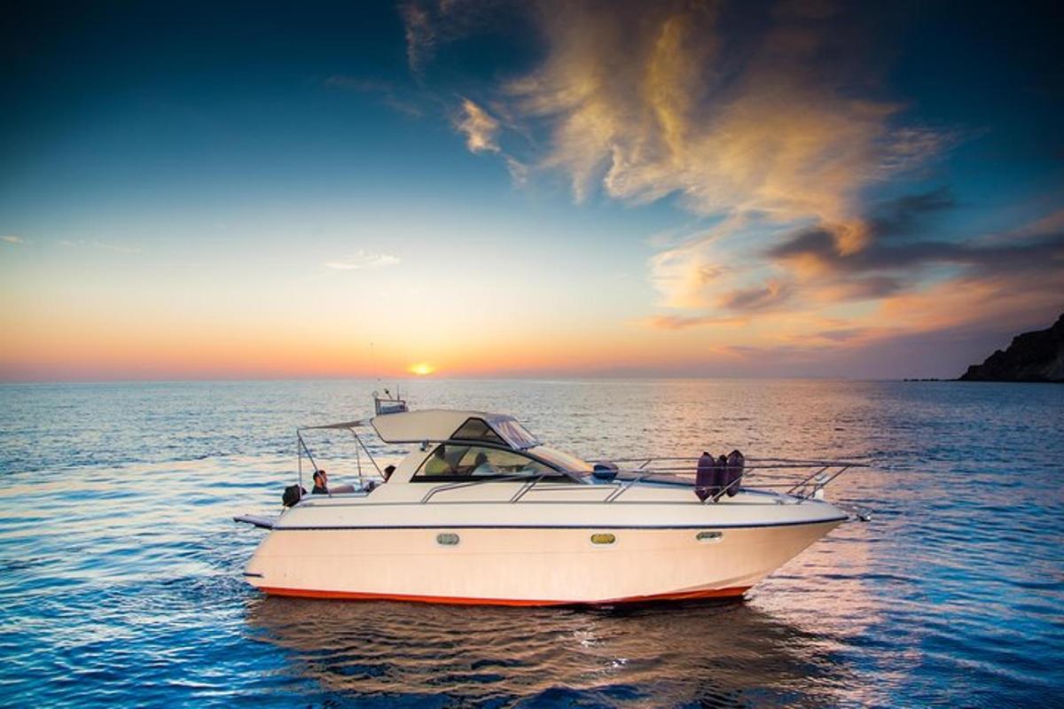 perahu putih di air dengan matahari terbenam di latar belakang
