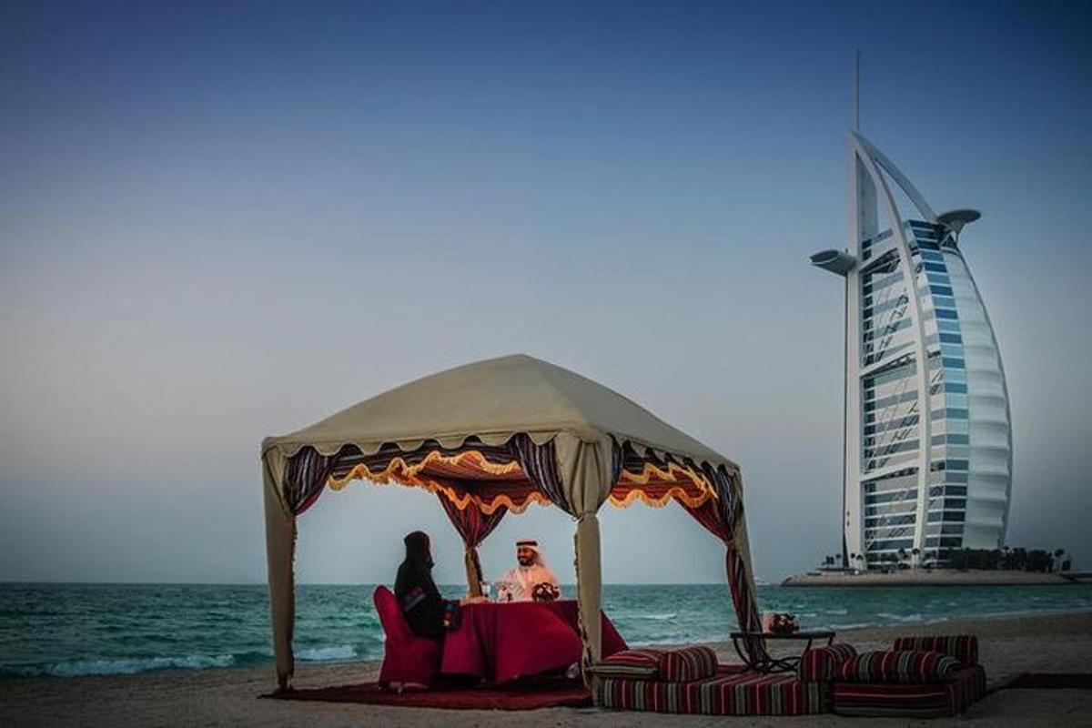 two people sitting under a gazebo on the beach