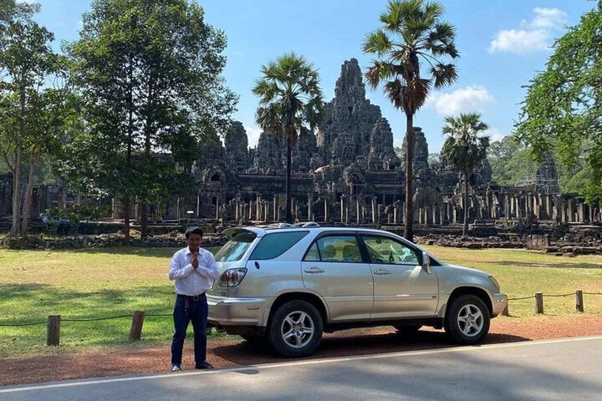 seorang lelaki berdiri di sebelah kereta di hadapan kuil