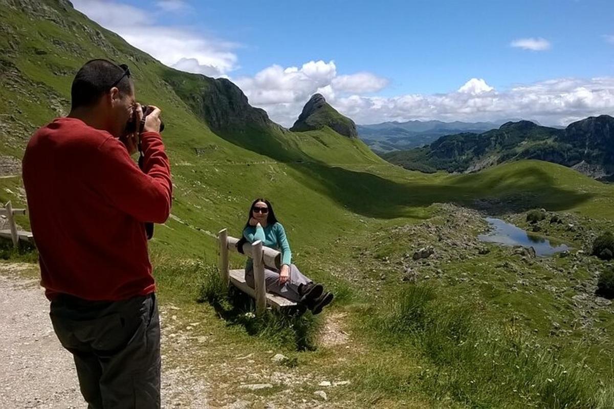 un bărbat care fotografiază o femeie așezată pe o bancă