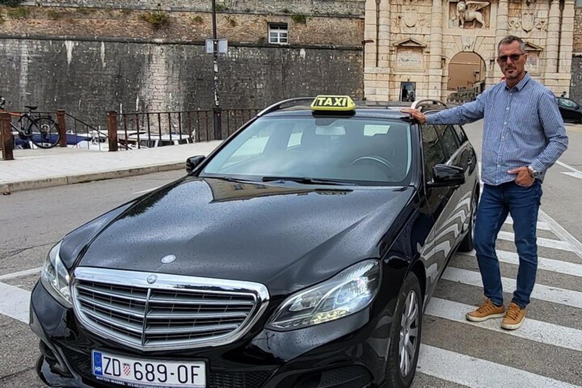 un uomo è in piedi accanto a un'auto nera