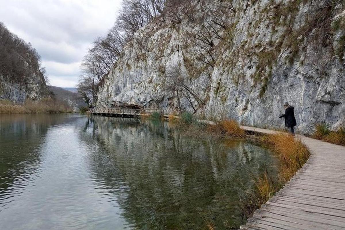 una persona che cammina su un sentiero accanto a uno specchio d'acqua