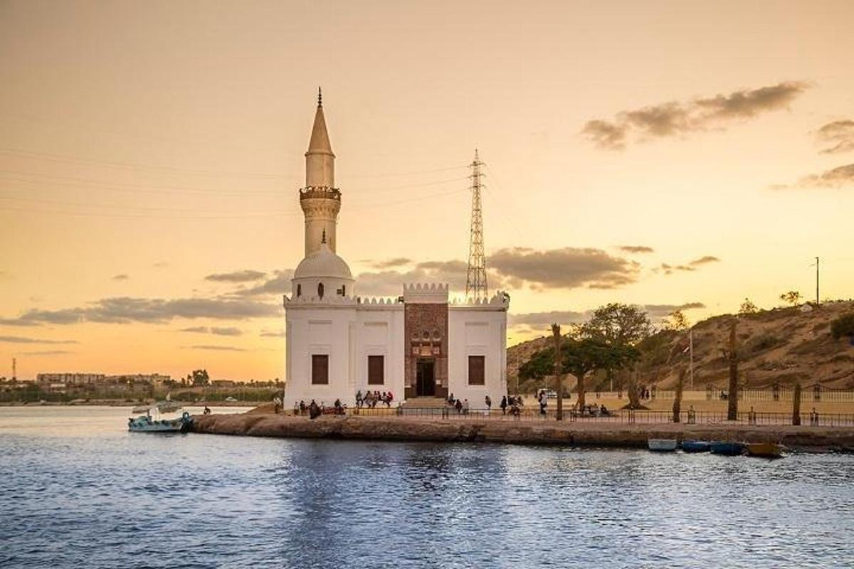 un gran edifici blanc amb una torre sobre l'aigua