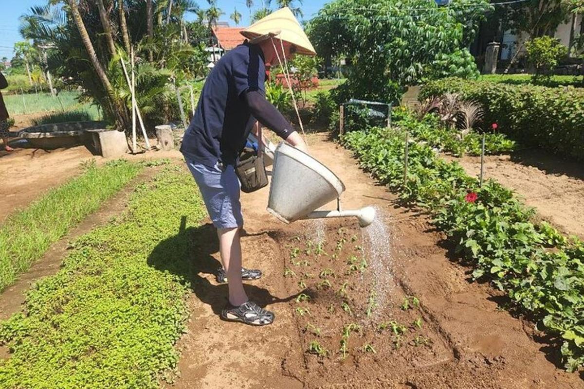 eine Person mit einem Gießtrichter in einem Garten