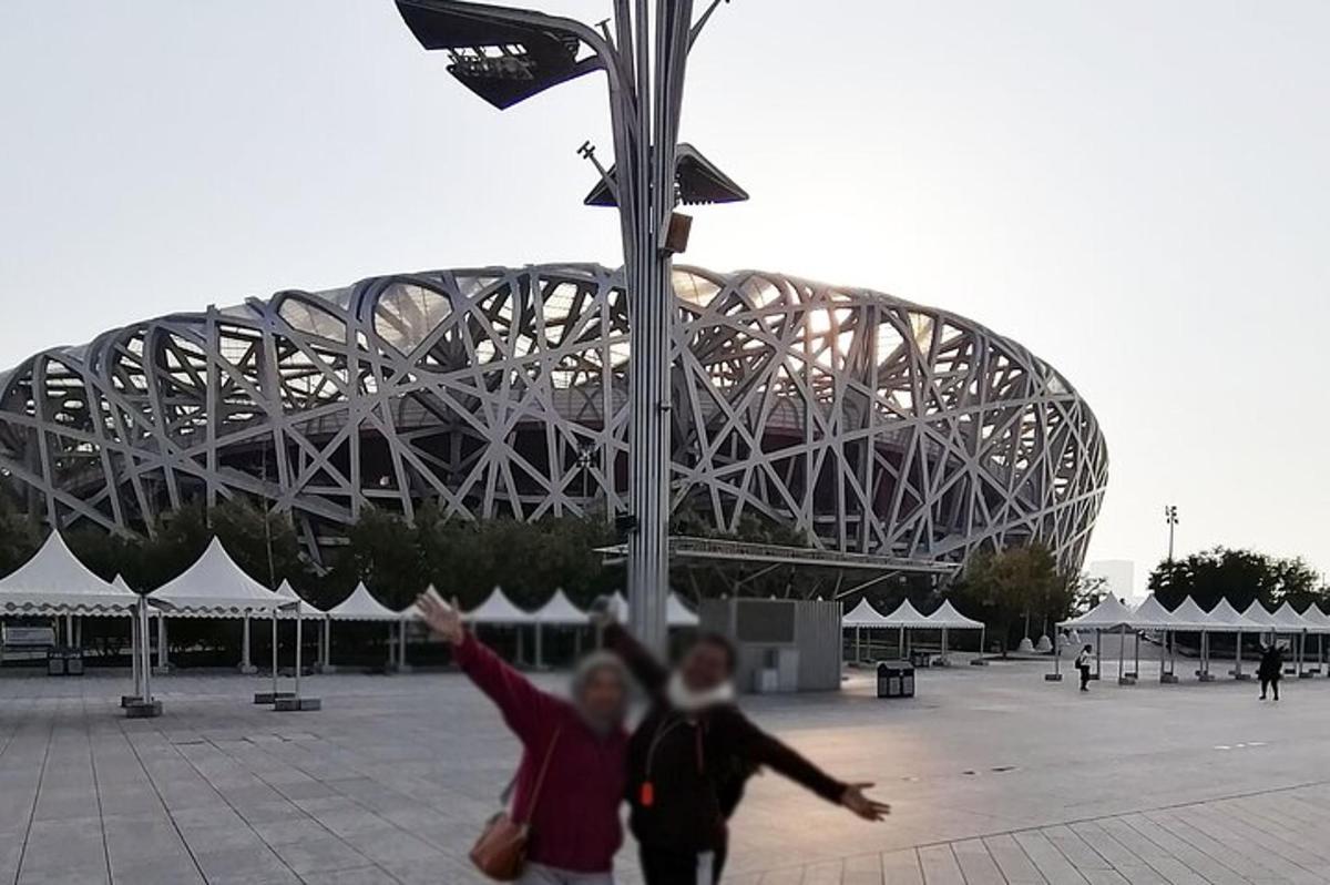 two people are walking in front of a stadium