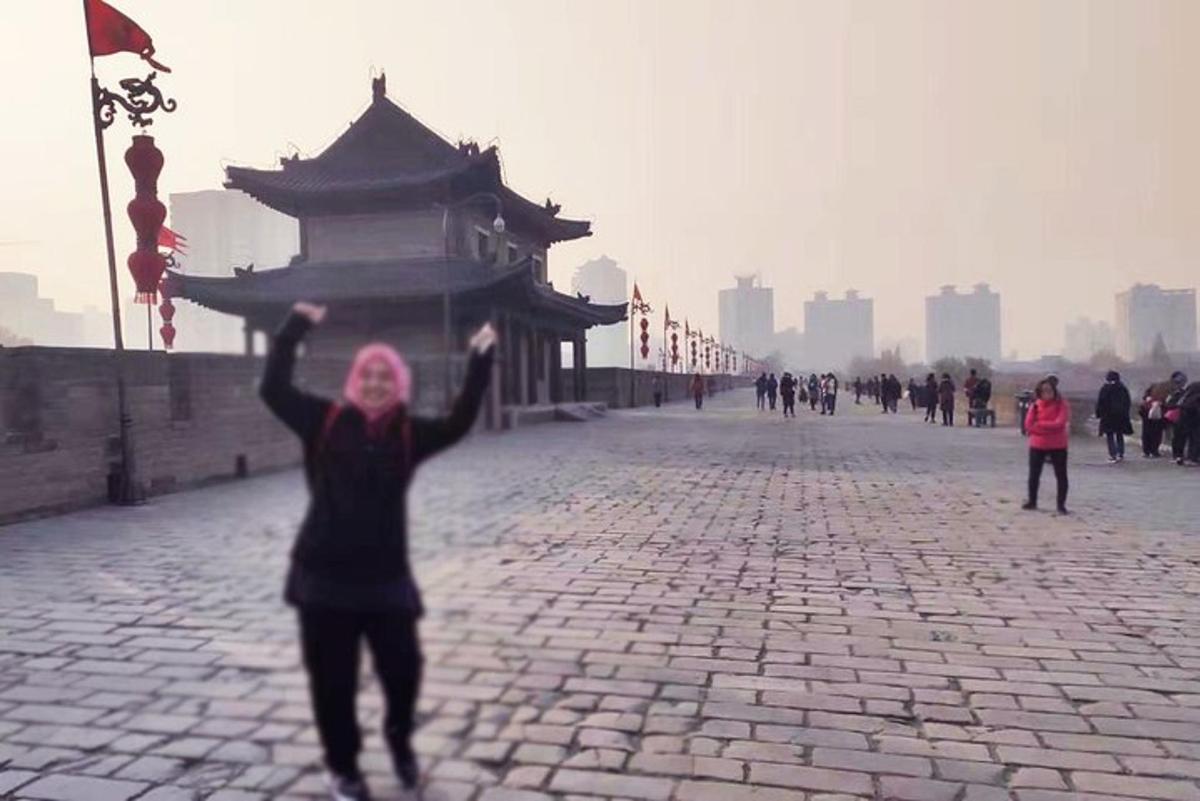 a woman is holding up a kite in a street
