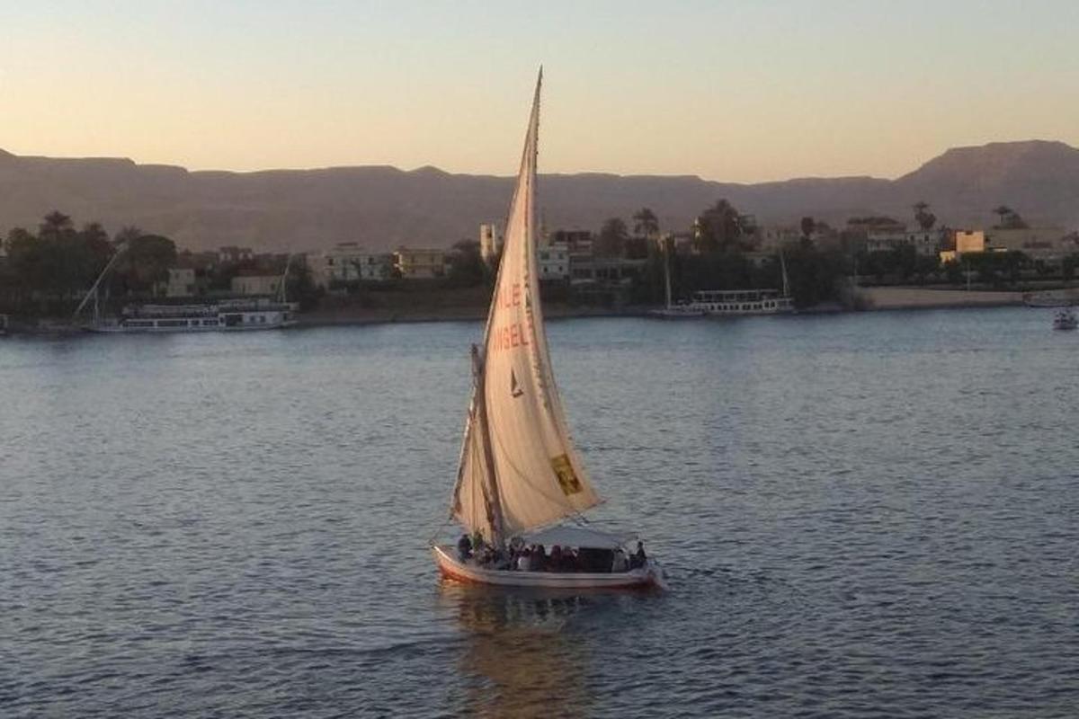 Un grupo de personas en un pequeño velero en el agua.