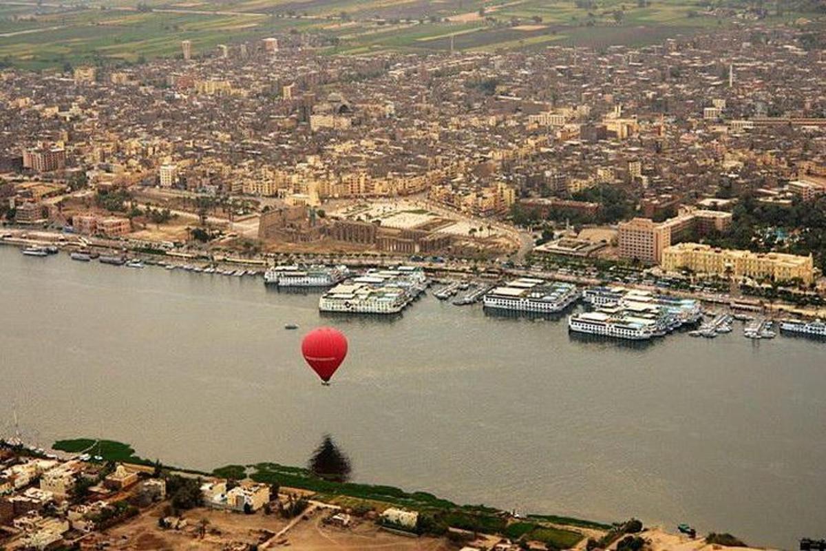 un globus vermell vola sobre una massa d'aigua
