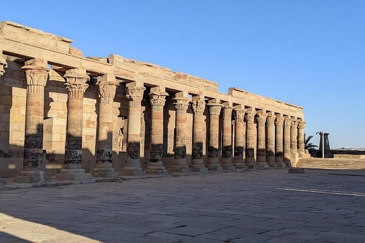Un gran edificio de piedra con columnas en una calle.