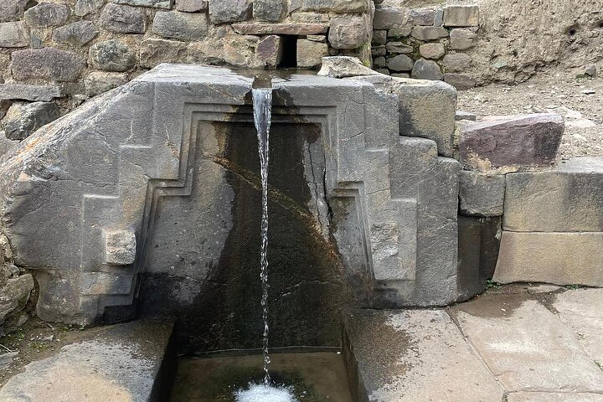 een waterfontein voor een stenen muur