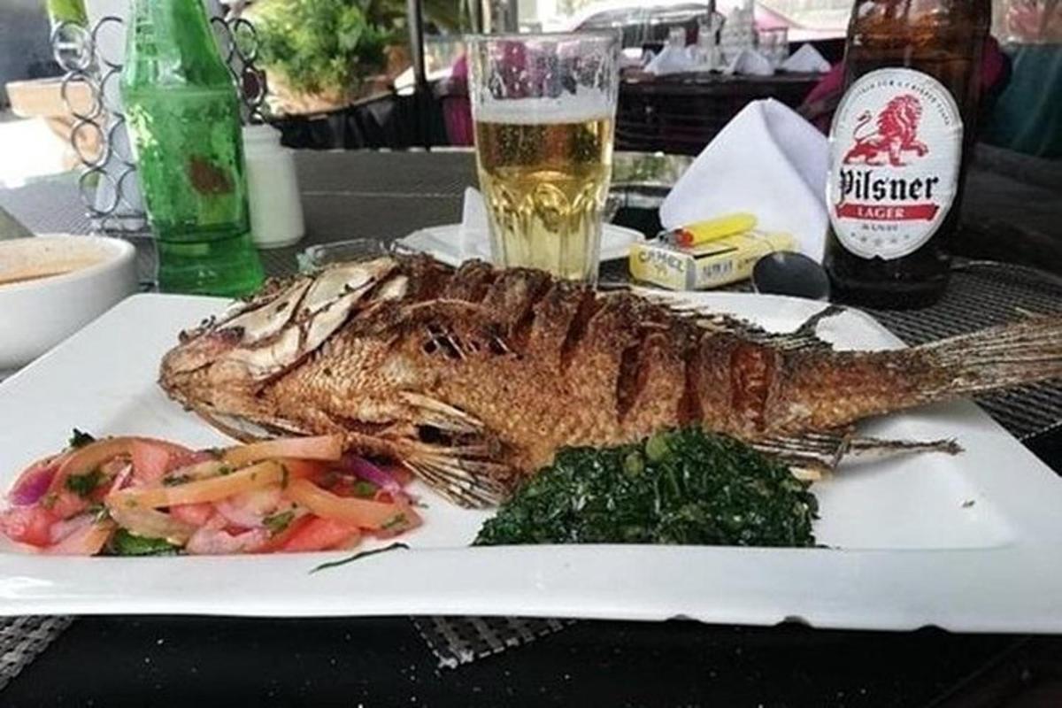 riba na krožniku na mizi s kozarcem piva