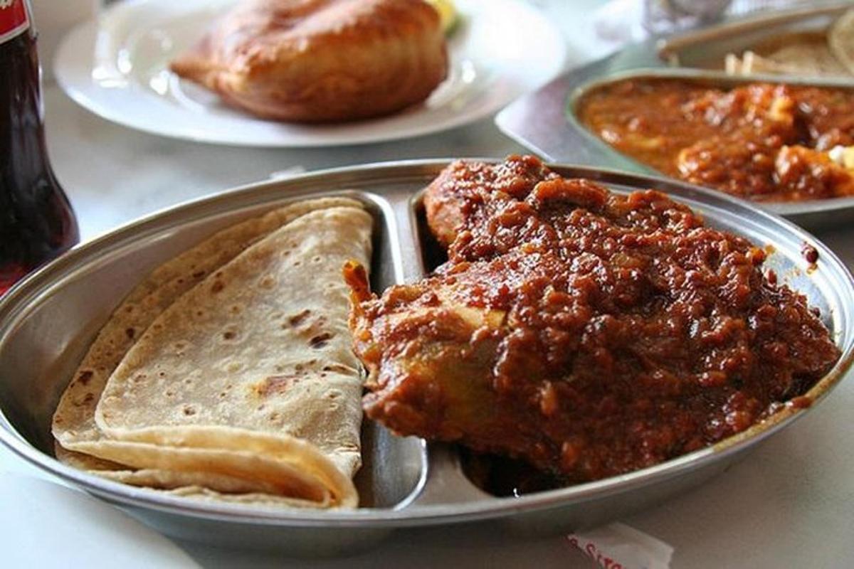 krožnik hrane z mesom in kruhom na mizi