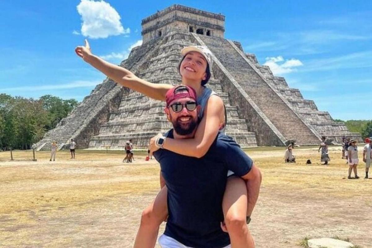isang lalaki na may hawak na babae sa harap ng pyramid