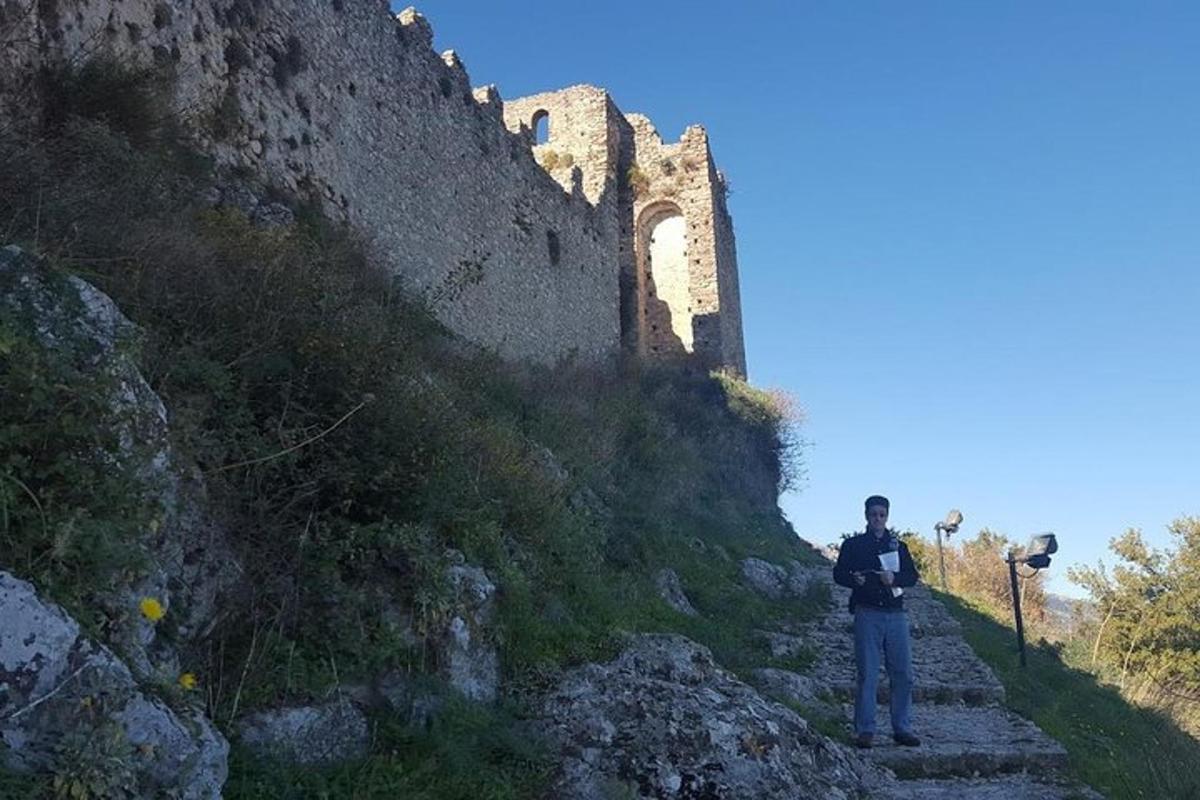 Un hombre parado en unas escaleras frente a un castillo.