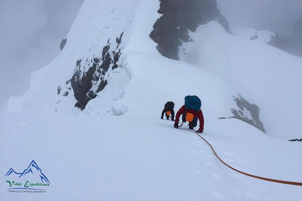 duas pessoas estão escalando uma montanha coberta de neve