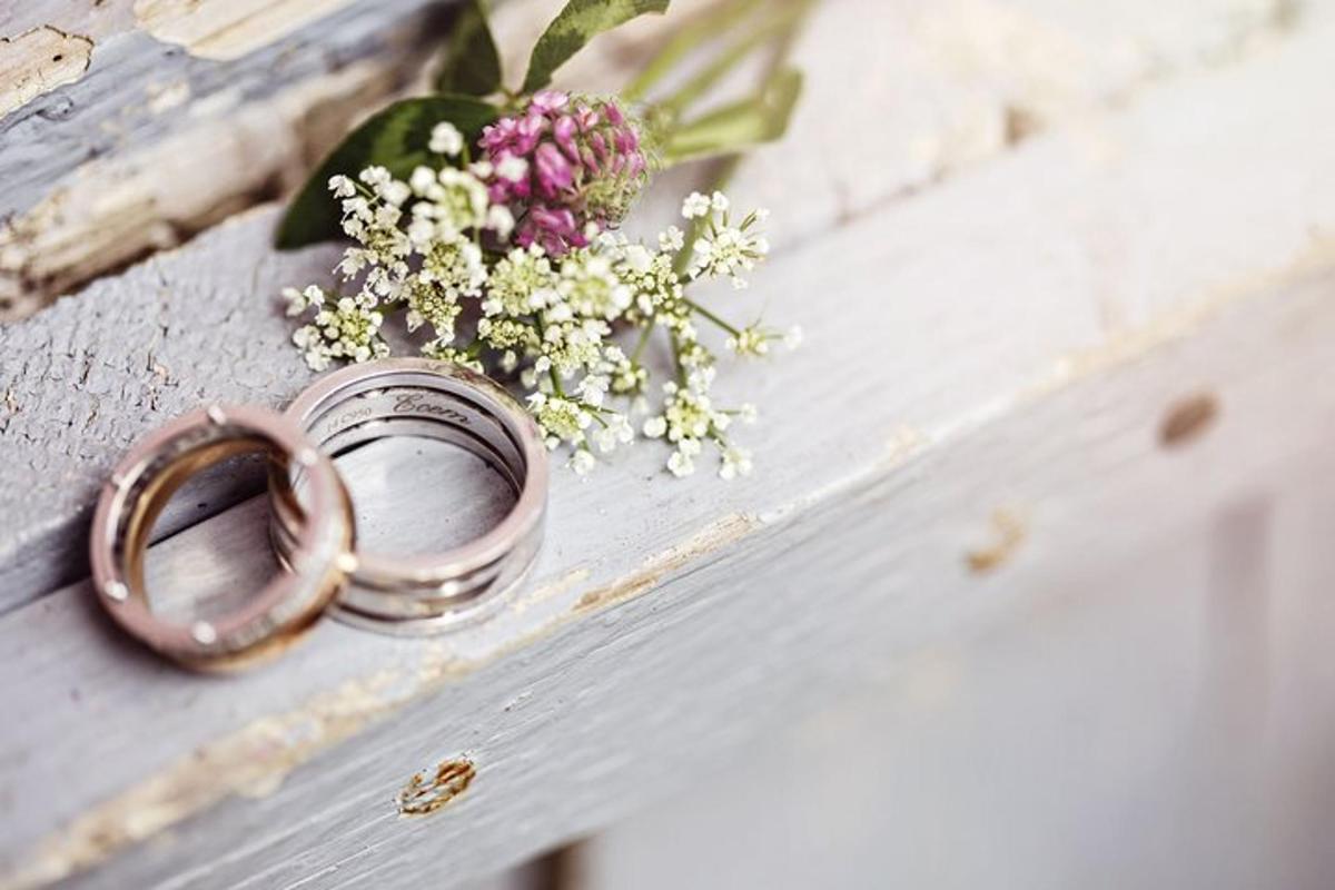 un anello nuziale e un mazzo di fiori su un cassetto