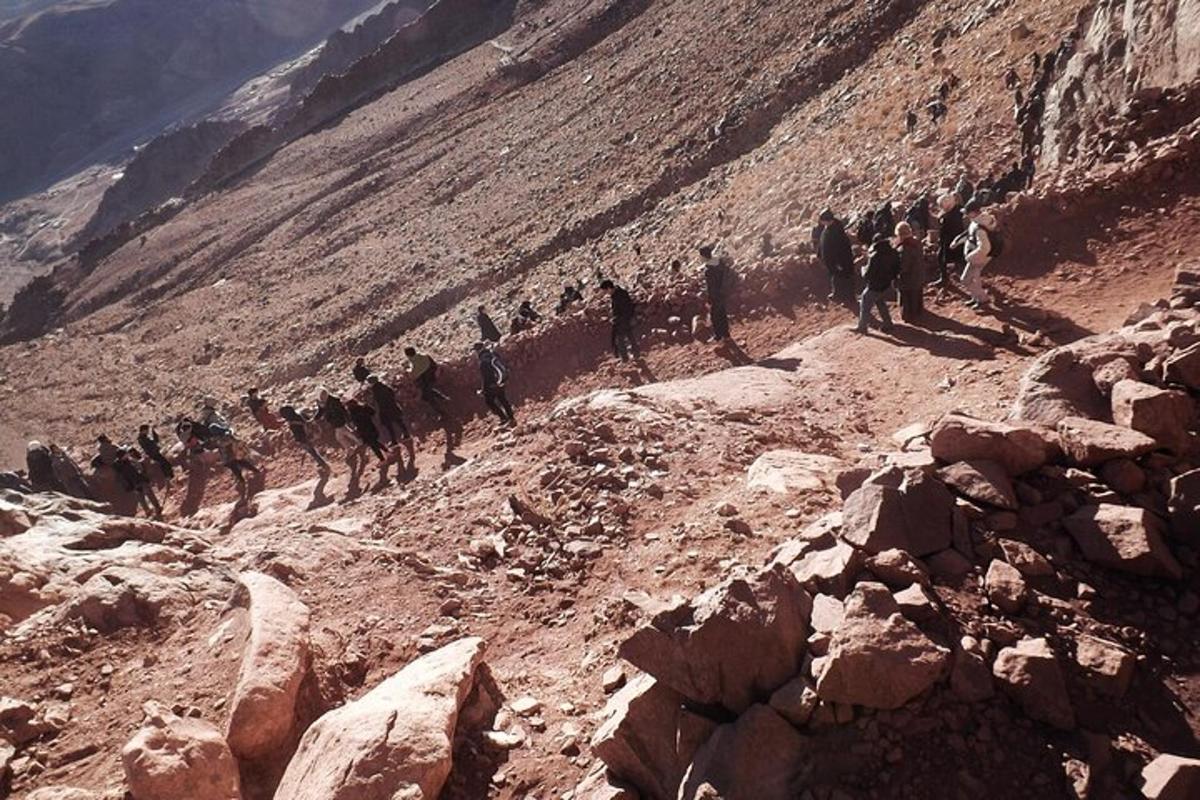 en gruppe mennesker som går på et steinete fjell