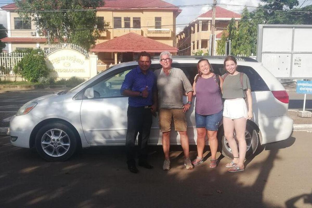 grupė žmonių, stovinčių priešais automobilį