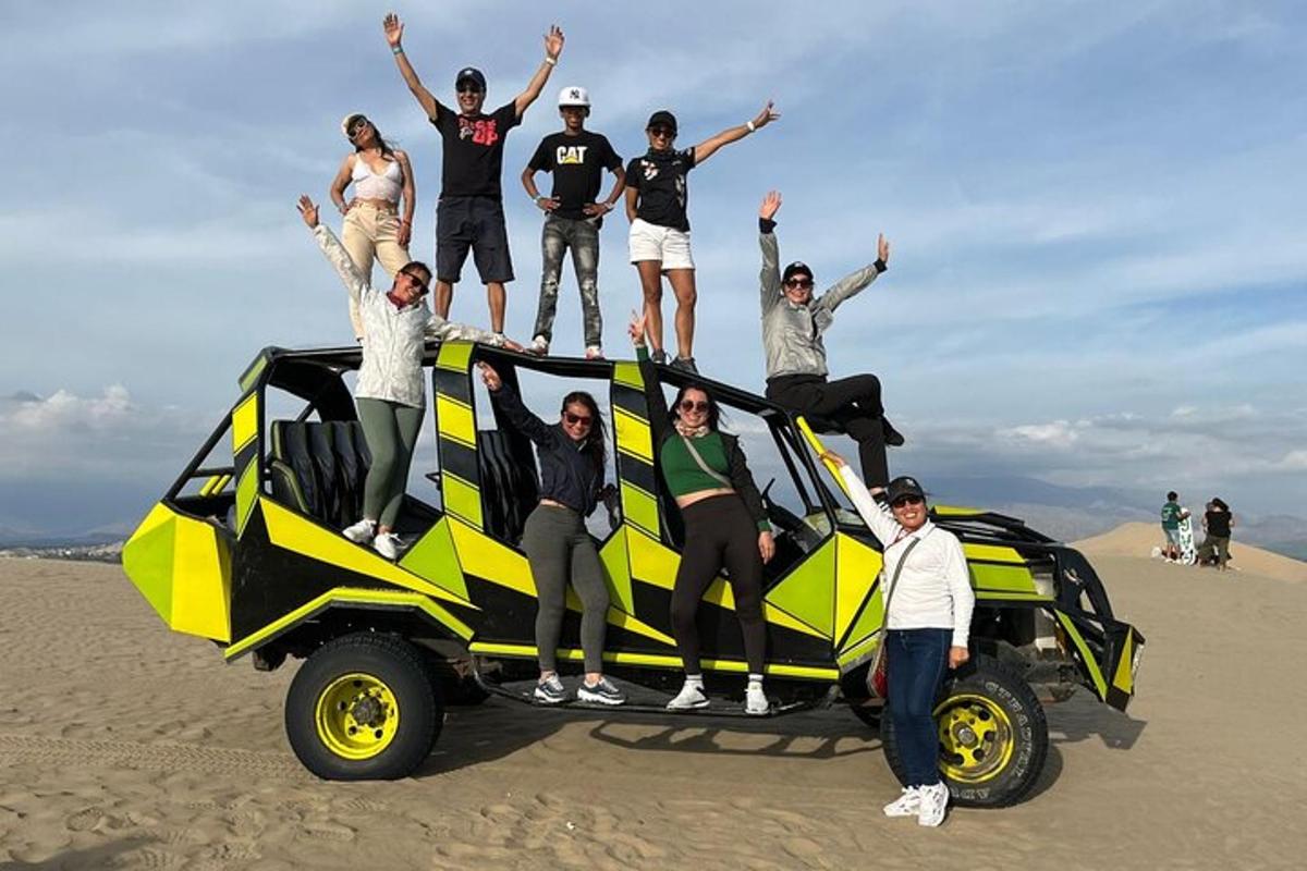 sekelompok orang berdiri di atas mobil di pantai