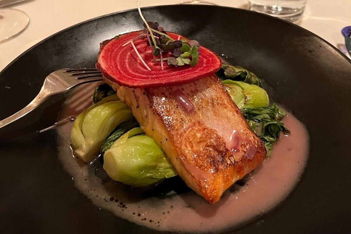 un plat de menjar amb un tros de peix i verdures