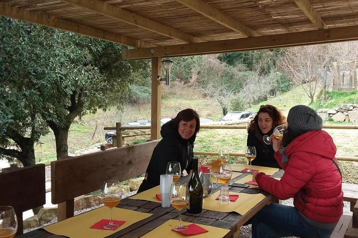 tre donne sedute a un tavolo con bicchieri di vino